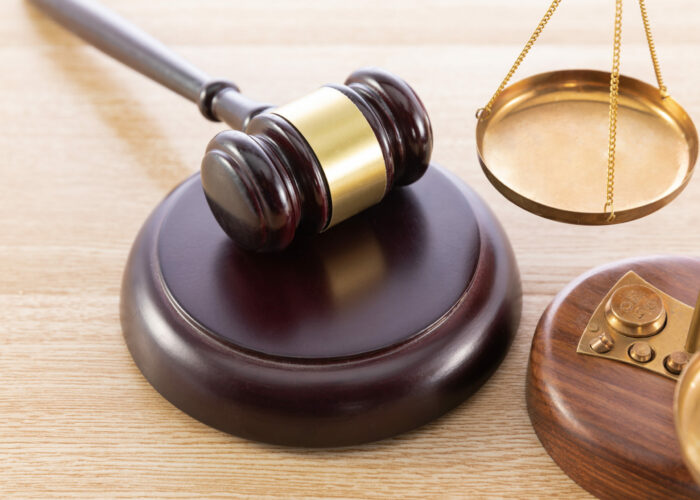 A high angle shot of a gavel and a scale on a wooden surface