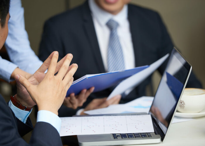 Financial reports on opened laptop of businessman